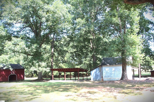 view of yard with a carport and an outdoor structure