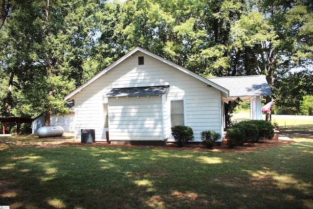 view of side of property with central AC unit and a lawn