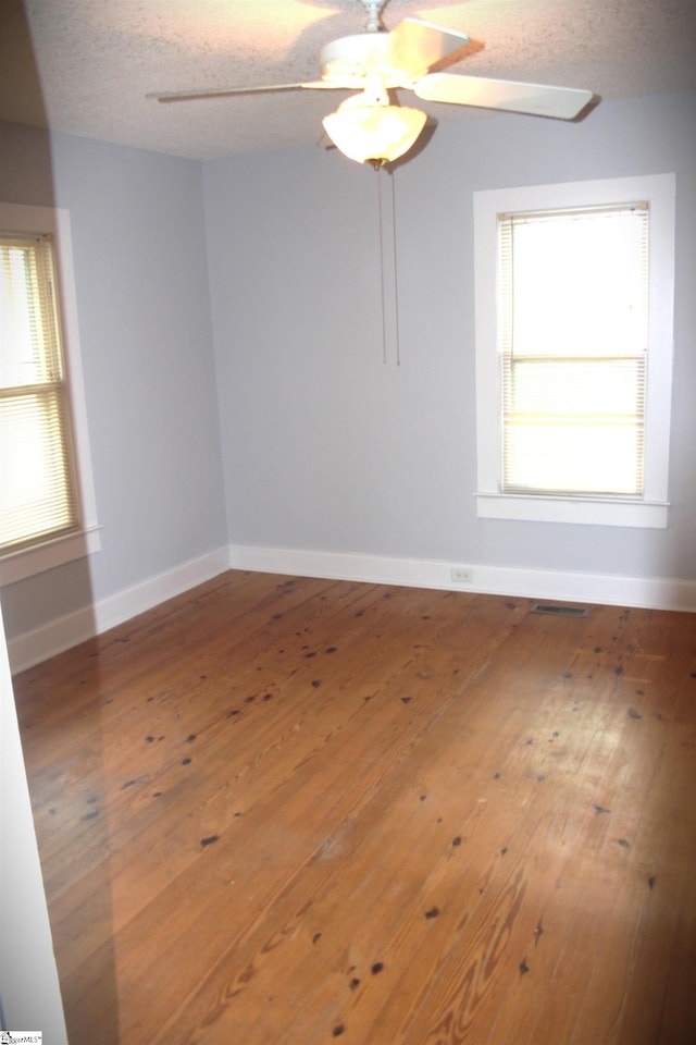 unfurnished room featuring a textured ceiling, ceiling fan, and hardwood / wood-style floors