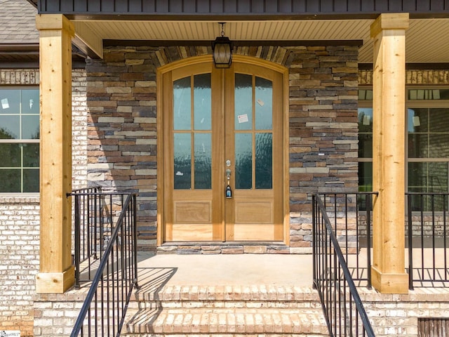 view of exterior entry featuring french doors and covered porch