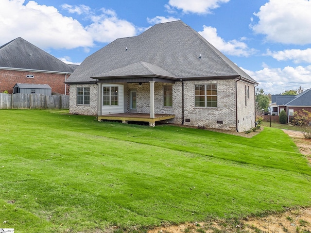 rear view of house featuring a wooden deck and a lawn