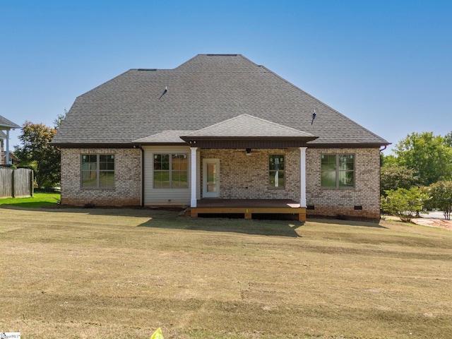 rear view of house featuring a wooden deck and a lawn