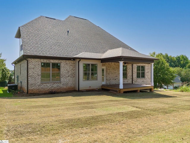 back of property with a deck and a lawn