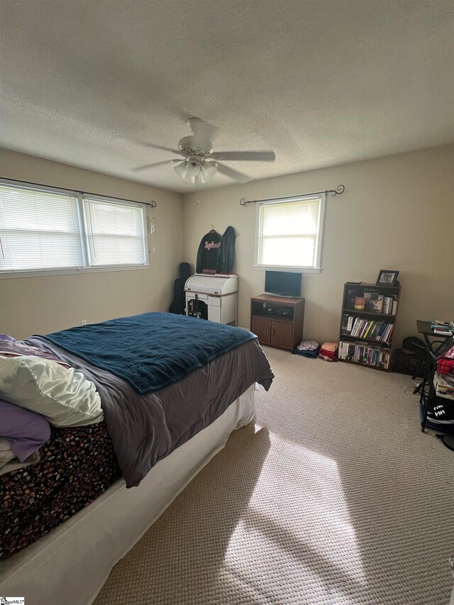 bedroom with carpet flooring, a textured ceiling, and ceiling fan