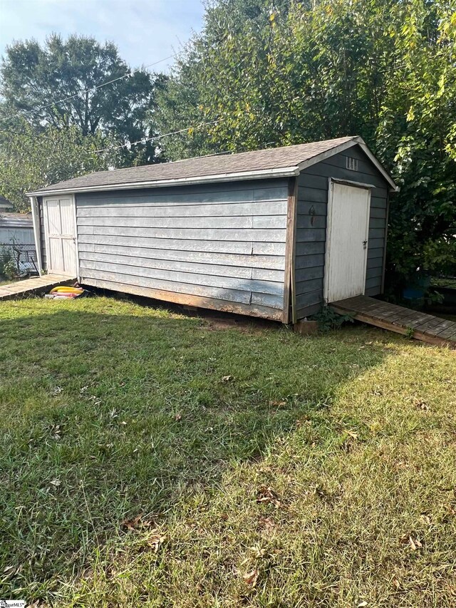 view of outbuilding featuring a lawn