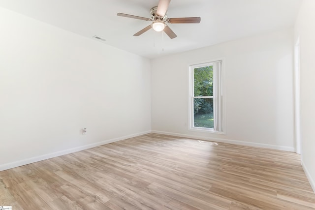 spare room featuring light wood-style flooring, visible vents, baseboards, and ceiling fan