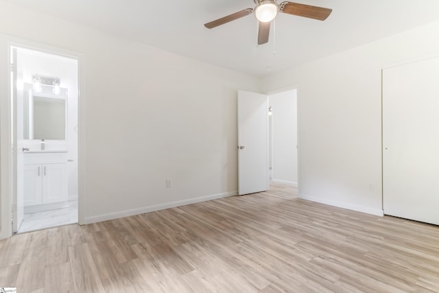 unfurnished bedroom with light wood-type flooring, baseboards, and ensuite bathroom