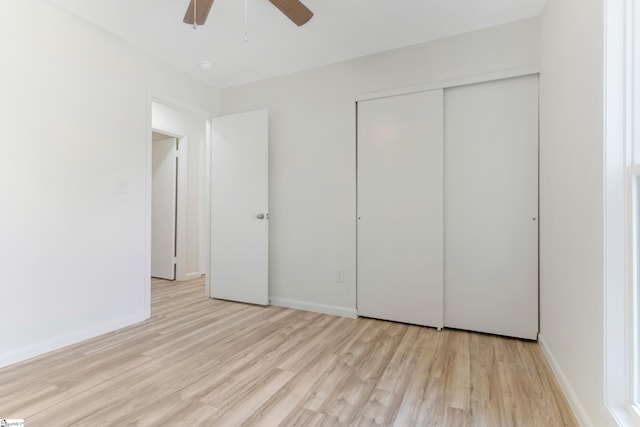 unfurnished bedroom with a ceiling fan, baseboards, light wood-type flooring, and a closet