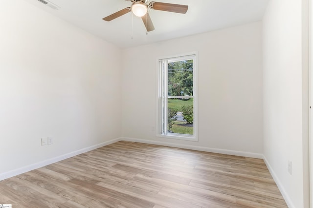 unfurnished room with visible vents, ceiling fan, light wood-type flooring, and baseboards