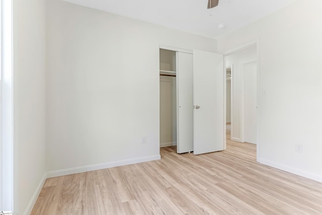 unfurnished bedroom featuring a ceiling fan, baseboards, a closet, and light wood finished floors