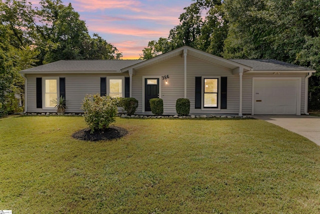 ranch-style house featuring concrete driveway, a lawn, a garage, and roof with shingles