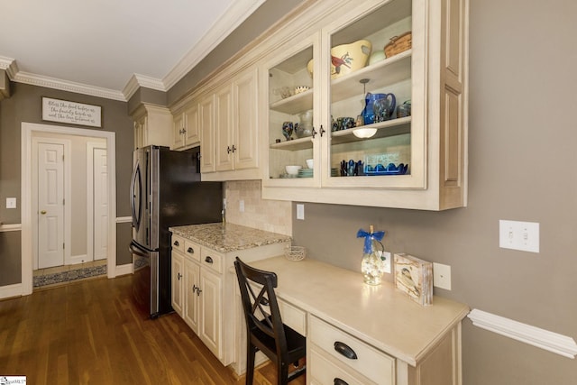 kitchen featuring built in desk, cream cabinets, crown molding, stainless steel fridge, and dark wood-type flooring