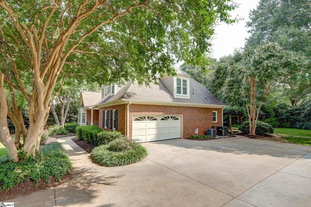 view of front of property with cooling unit and a garage