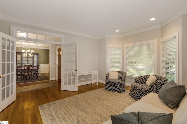 living room featuring a notable chandelier, hardwood / wood-style flooring, crown molding, and french doors