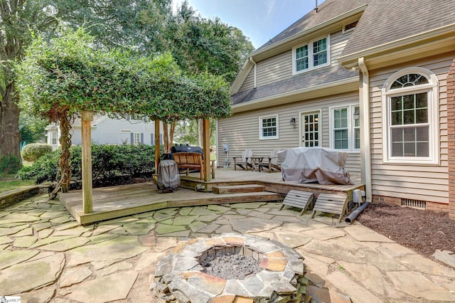 view of patio with an outdoor fire pit, area for grilling, and a deck