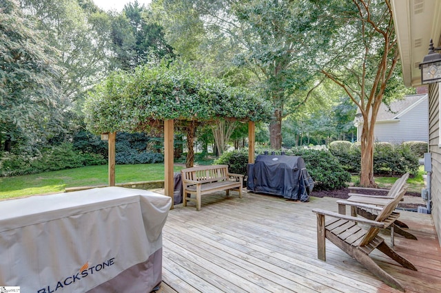 wooden terrace featuring area for grilling and a yard