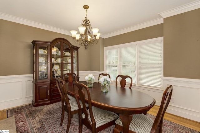 dining room featuring wood-type flooring, crown molding, and a notable chandelier