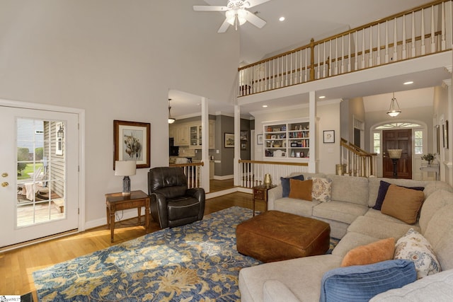 living room featuring a towering ceiling, hardwood / wood-style floors, and ceiling fan