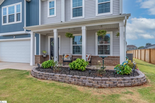 view of front of house featuring a garage, a front lawn, and a porch