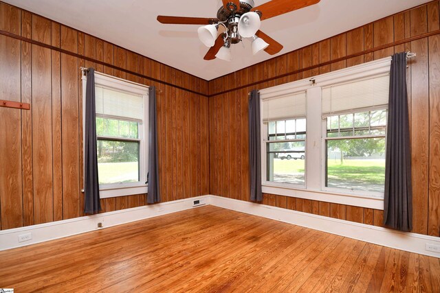 empty room featuring plenty of natural light, hardwood / wood-style floors, and ceiling fan