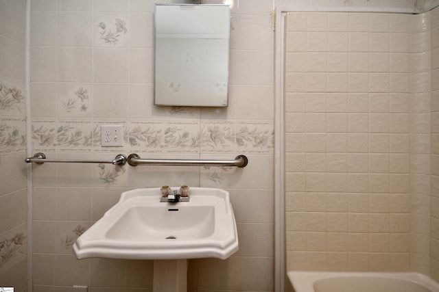 bathroom featuring tile walls and sink