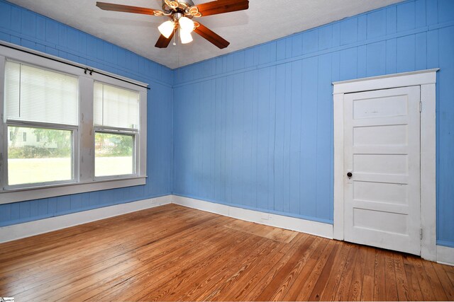 unfurnished room with ceiling fan, wood-type flooring, and a textured ceiling