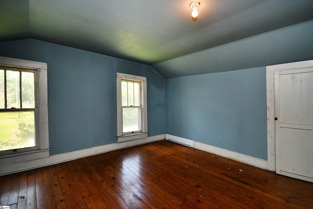 additional living space with a healthy amount of sunlight, dark hardwood / wood-style flooring, and vaulted ceiling