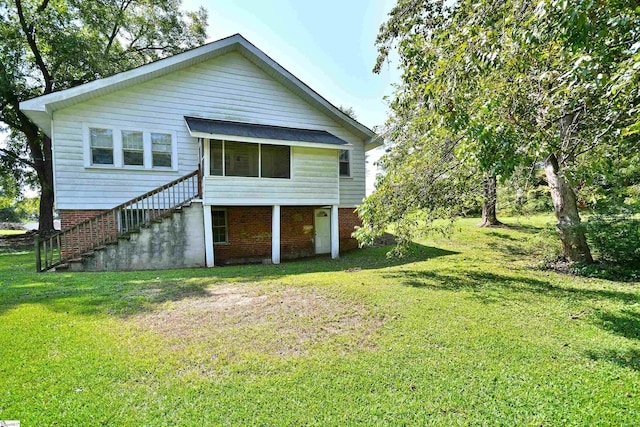 rear view of house featuring a lawn