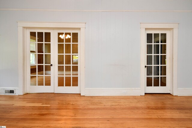 entryway with crown molding, french doors, and hardwood / wood-style flooring