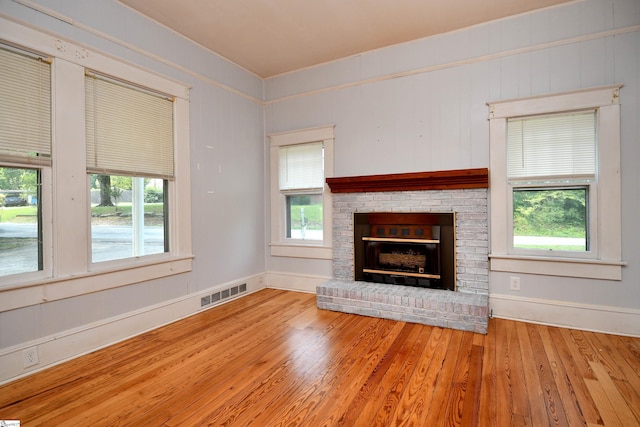 unfurnished living room featuring a fireplace and light hardwood / wood-style flooring