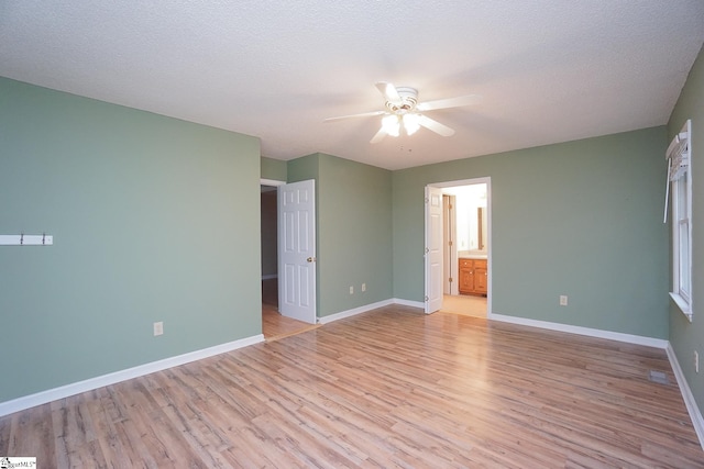 empty room with light wood-type flooring, ceiling fan, and a textured ceiling