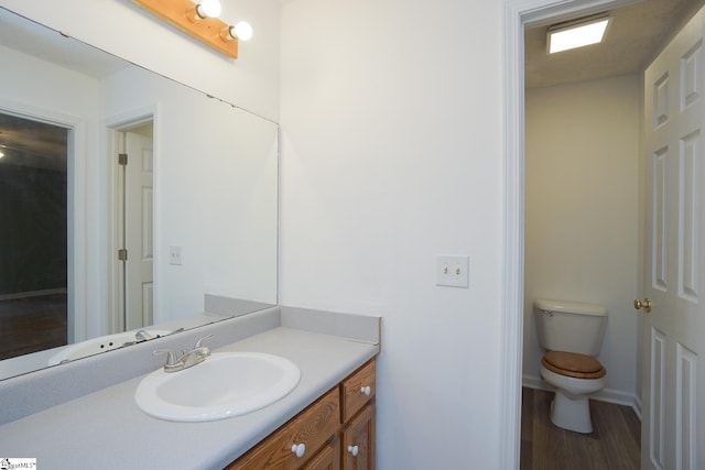 bathroom featuring vanity, toilet, and hardwood / wood-style floors