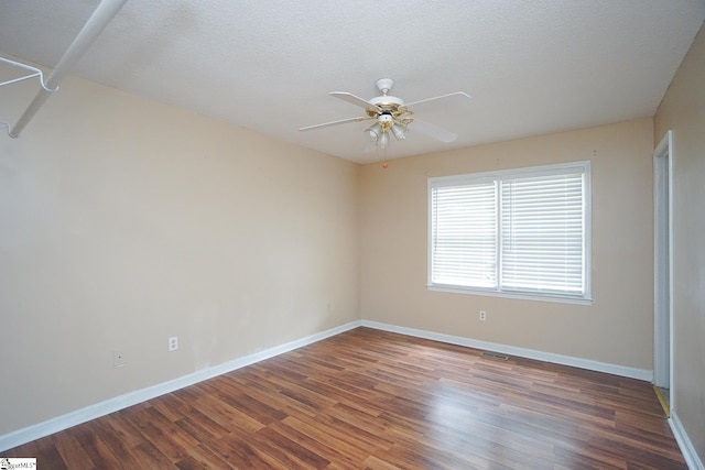 empty room featuring ceiling fan, dark hardwood / wood-style flooring, and a textured ceiling