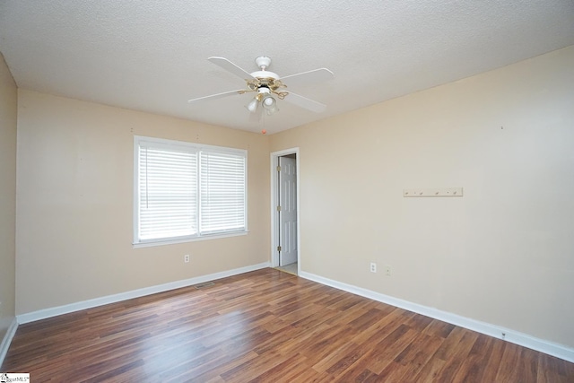 empty room featuring a textured ceiling, dark wood-type flooring, and ceiling fan