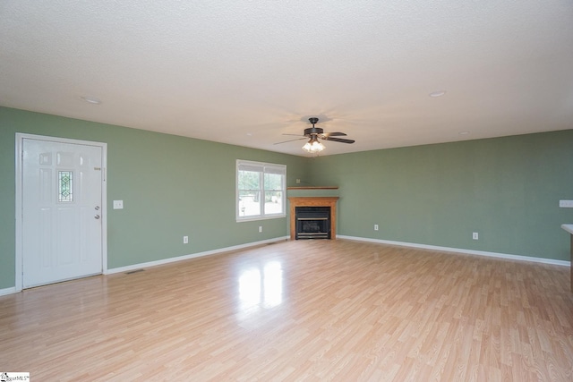 unfurnished living room featuring a textured ceiling, light hardwood / wood-style flooring, and ceiling fan