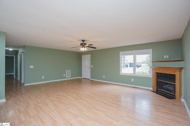 unfurnished living room with a textured ceiling, ceiling fan, and light wood-type flooring