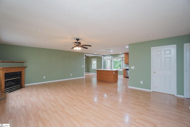 unfurnished living room with light wood-type flooring, ceiling fan, and a textured ceiling