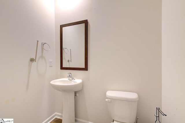 bathroom with toilet and baseboards