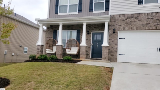 property entrance with covered porch, a garage, and a yard