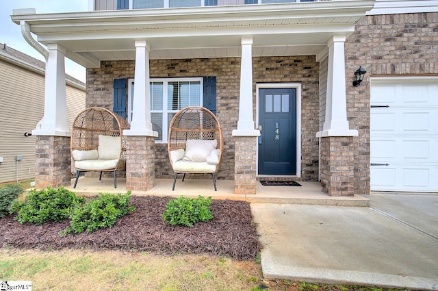 view of exterior entry with a garage and a porch