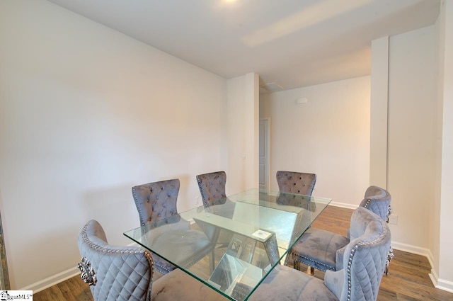 dining area with baseboards and wood finished floors