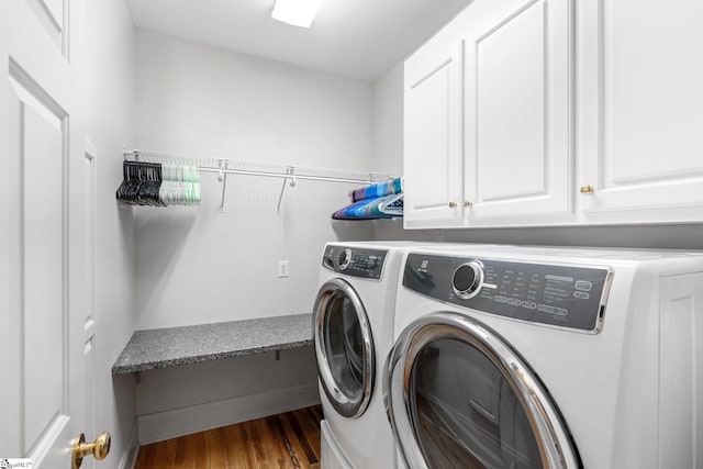 laundry room with cabinets, dark hardwood / wood-style flooring, and washing machine and clothes dryer