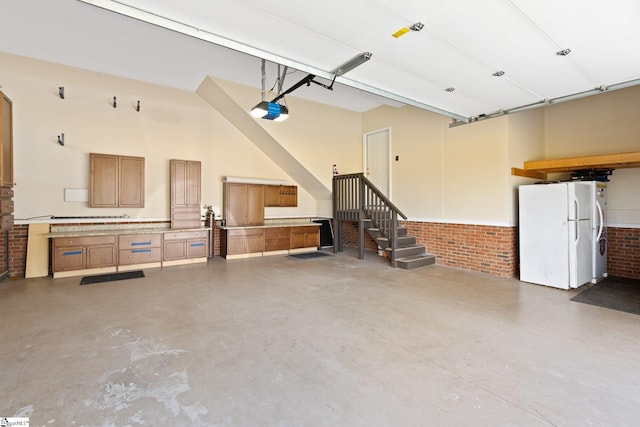 garage with white refrigerator and a garage door opener