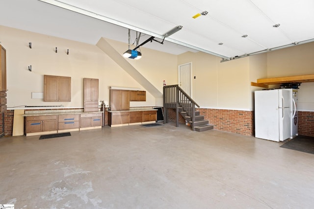 garage with a garage door opener and freestanding refrigerator