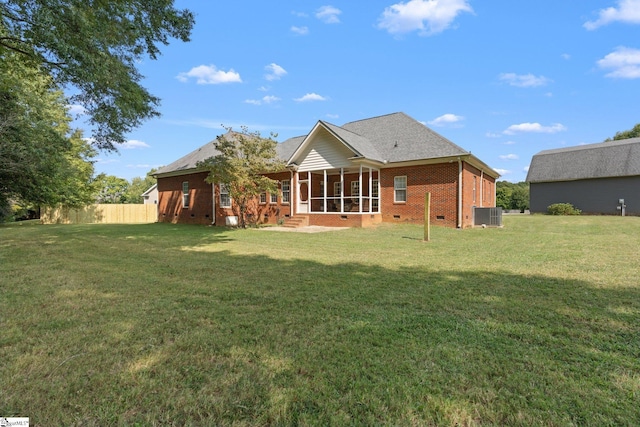 rear view of property featuring a lawn, fence, brick siding, and crawl space