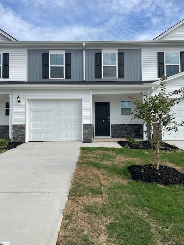 view of front facade featuring a front yard, a garage, and a porch