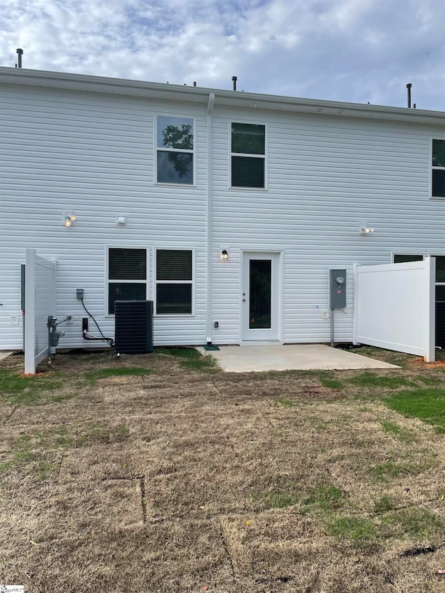 back of house with central air condition unit, a yard, and a patio