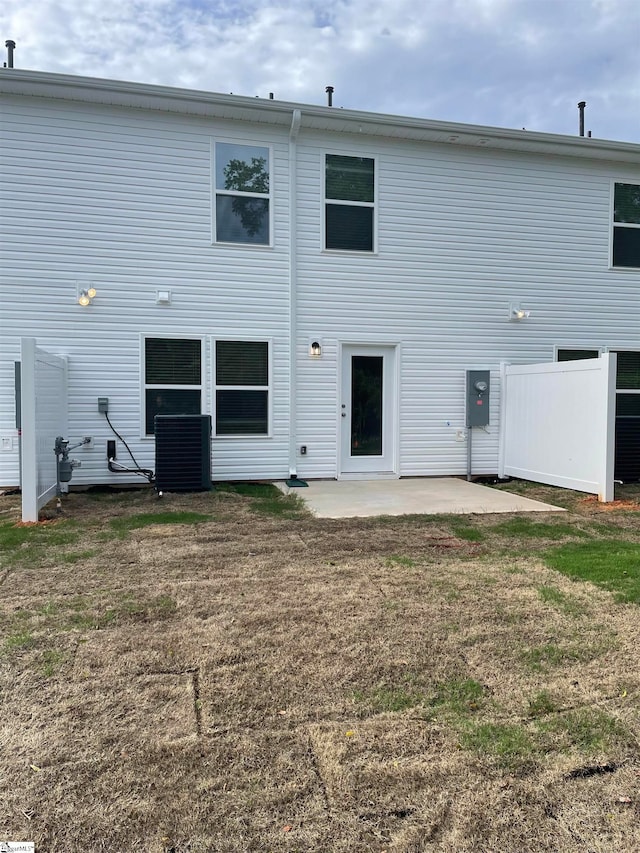 back of property featuring cooling unit, a yard, and a patio area