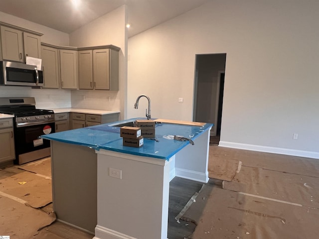 kitchen featuring vaulted ceiling, gray cabinetry, stainless steel appliances, decorative backsplash, and sink