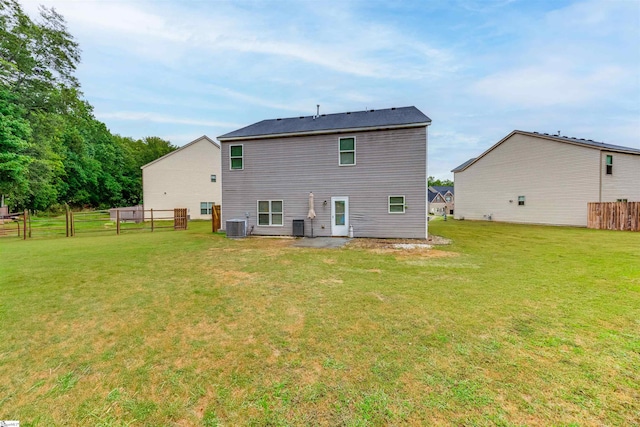 rear view of house with a yard and cooling unit